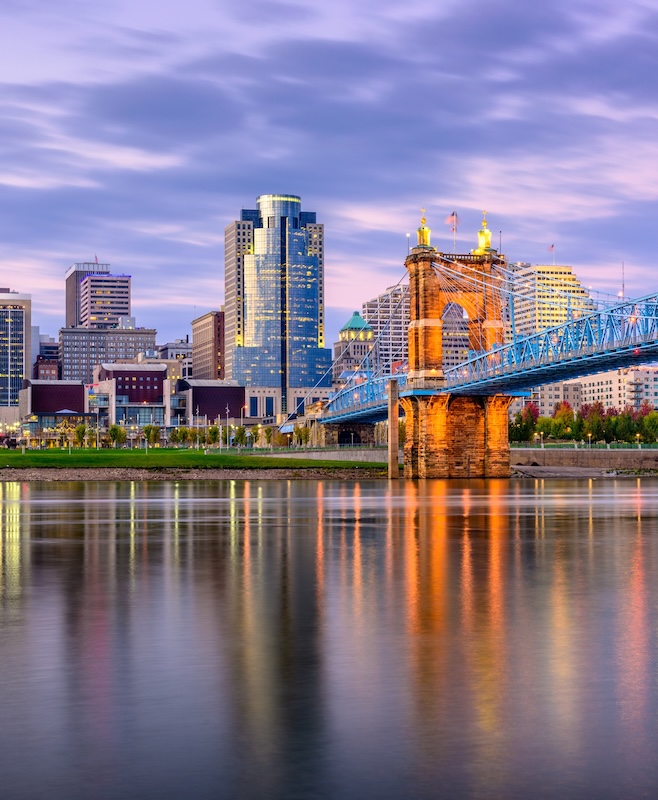 Cincinnati, Ohio, USA downtown skyline and bridge on the river at dusk.